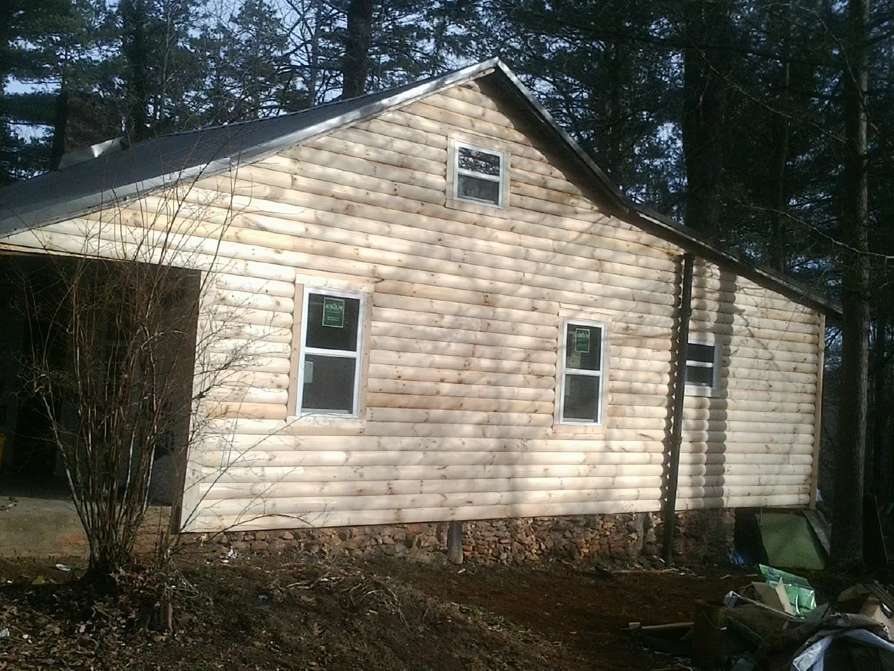 New log siding and dark metal roofing on a gable end in Union
